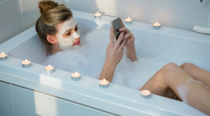 Woman using a Phone in the Bath - Soakology Blog